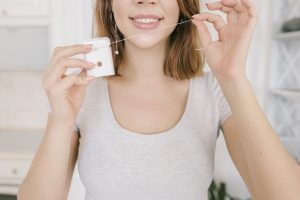 Woman Flossing Teeth